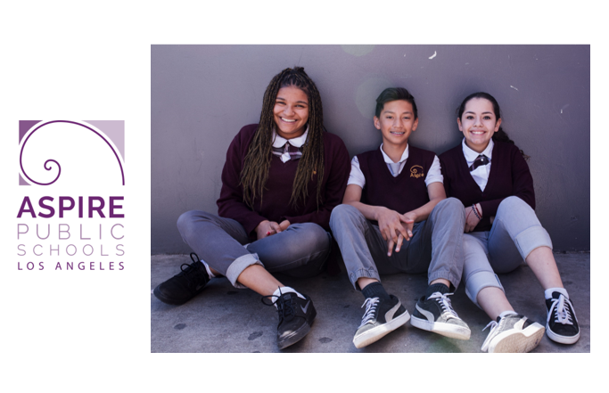 Three Aspire students sitting on a wall